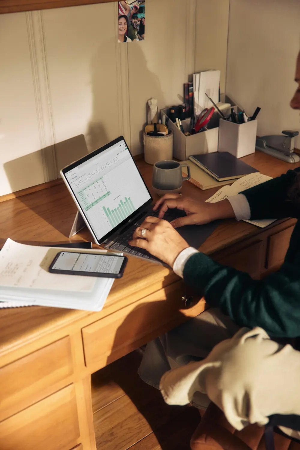 Reviewing financial statements on a laptop at a wooden desk